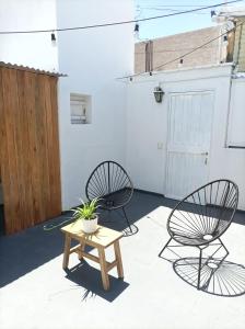 two chairs and a table in the middle of a patio at Buenaventura Apartments Terrazas in Mendoza