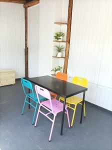 a table with four colorful chairs around it at Buenaventura Apartments Terrazas in Mendoza