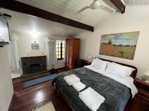 um quarto com uma cama grande e uma lareira em Chalés da montanha em Itaipava