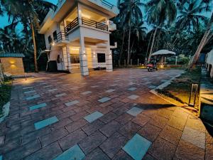 ein Haus mit einer steinernen Einfahrt davor in der Unterkunft Corniche Beach Resort in Mulappilangād