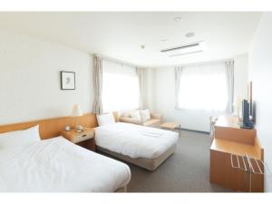 una habitación de hotel con dos camas y un sofá en HOTEL TRUNK WAKKANAI - Vacation STAY 92601v, en Wakkanai