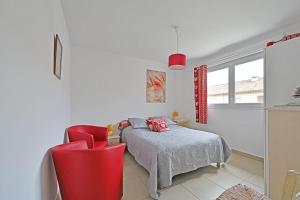 1 dormitorio con 1 cama y 2 sillas rojas en Îlot COQUELICOT - PARKING GRATUIT SECURISE - AC CLiM - ASCENSEUR - BALCON, en LʼIsle-sur-la-Sorgue