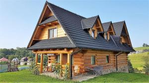 a log cabin with a black roof at Chata Albertówka in Groń