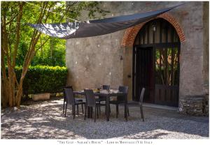 una mesa y sillas frente a una casa en The Gulf Sailor's Cottage - Lago Maggiore, en  Monvalle 