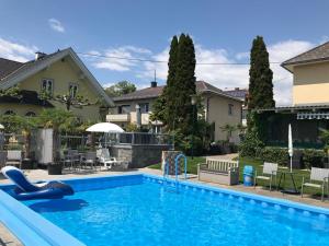 a swimming pool in a yard next to a house at Ferienanlage Seehof in Krumpendorf am Wörthersee