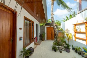 ein Haus mit einem Innenhof mit Pflanzen und einer Tür in der Unterkunft Island Holiday Lodge in Felidhoo 