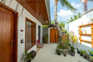 a house with a courtyard with plants and a door at Island Holiday Lodge in Keyodhoo