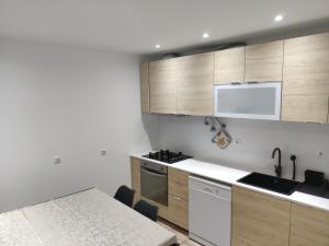 a kitchen with wooden cabinets and a table and a sink at Costa House in Nazaré +8 photos