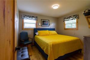 ein Schlafzimmer mit einem gelben Bett und einem Stuhl in der Unterkunft Steps to Lake on the Mountain - License ST-2020-0324 R1 in Picton