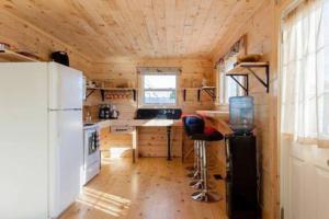 een kleine keuken met een koelkast en een tafel bij Steps to Lake on the Mountain - License ST-2020-0324 R1 in Picton