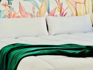 a green blanket laying on a white bed at Canaryislandshost l Sal de Mar in Puerto del Carmen