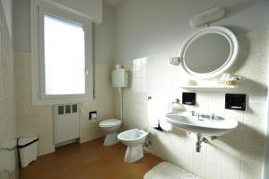 łazienka z umywalką, toaletą i lustrem w obiekcie Albergo "da Mario" w mieście Pianoro +15 zdjęć