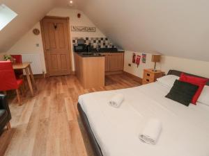 um quarto com uma grande cama branca e uma cozinha em St Dolmen em Embleton