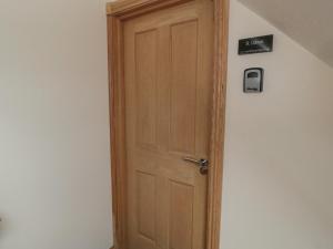 a wooden door in the corner of a room at St Dolmen in Embleton +37 photos