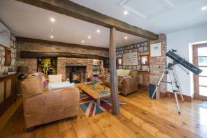 a camera in a living room with a brick fireplace at Crow House Barn in Copgrove