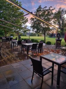 een groep tafels en stoelen op een patio bij L'Ulivo Italienische Restaurant und Pension in Pleiskirchen