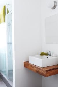 a bathroom with a white sink on a wooden shelf at Mengi Countryside in Kjarnholt
