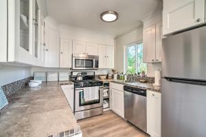 una cocina con armarios blancos y electrodomésticos de acero inoxidable en Cozy Cali Condo, Walk to Summerland Beach!, en Summerland