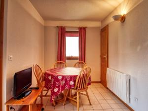 a dining room with a table and chairs and a television at Appartement Morillon 1100, 3 pièces, 6 personnes - FR-1-642-37 in Morillon