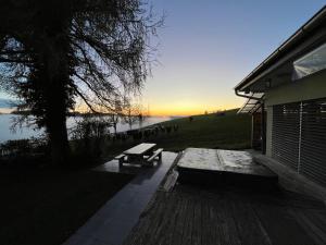 a bench sitting on a deck next to a lake at Maison chez Louis in Asuel