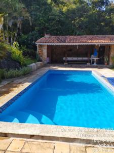 阿蒂巴亞的住宿－Chale em Atibaia，房子前面的蓝色游泳池