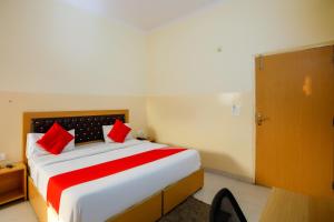 Indirapuram的住宿－Capital O Crosswind Gold，一间卧室配有一张带红色枕头的大床