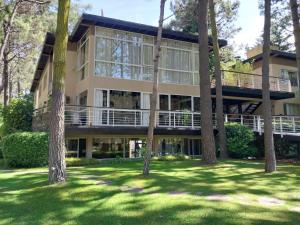 a large building with trees in front of it at Sonidos Del Bosque in Mar de las Pampas