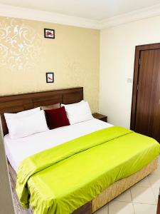 a bedroom with a large bed with a yellow blanket at OD-V!CK'S TOPVIEW, WUSE DISTRICT, Stable Power, Tight Security in Abuja