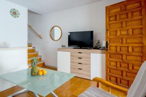 Una sala de estar con una mesa y un televisor. en Bajo del Sol, en Torrevieja