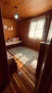 um pequeno quarto com 2 camas e uma janela em Chale em Atibaia em Atibaia