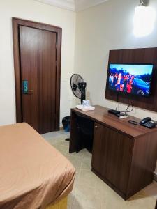 a hotel room with a television on a desk at OD-V!CK'S TOPVIEW, WUSE DISTRICT, Stable Power, Tight Security in Abuja