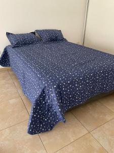 1 cama con edredón azul y puntos blancos en Hermoso Departamento Tipo Loft -Mendoza en Godoy Cruz