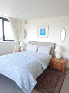 a white bedroom with a bed and a window at The Quarry House in Carlingford
