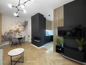 a living room with a dining table and a television at Apartament w centrum z dużym tarasem w centrum, ulica Kilińskiego in Łódź