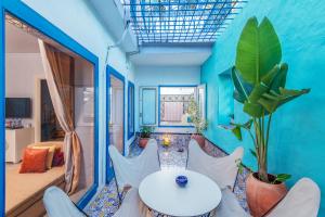 Habitación con pared azul, mesa y sillas en La Demeure en Sidi Bou Saïd