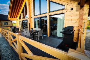 a wooden deck with a grill and a table at Vila Elis in Veľká Lomnica