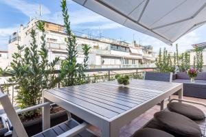 una mesa y sillas en un balcón con un edificio en Central chic flat with terrace btw Syntagma & Monastiraki en Athens
