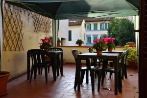 a patio with tables and chairs under a green umbrella at L'Acchiappasogni in Florence