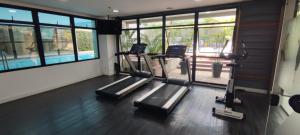 un gimnasio con 3 cintas de correr en una habitación con ventanas en Moema Flat Luxo, Macuco, en São Paulo