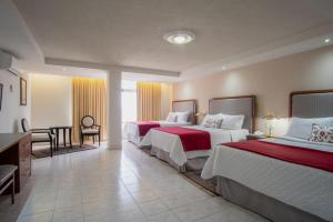 ein Hotelzimmer mit 2 Betten und einem Schreibtisch in der Unterkunft Hotel del Parque in Matehuala