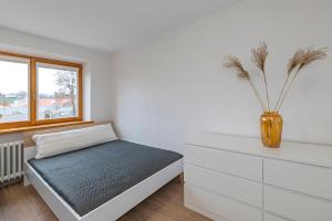 a bedroom with a bed and a vase on a dresser at Archcathedral studio apartment by Polo Apartments in Kaunas