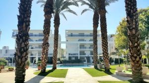 a group of palm trees in front of a building at Barak Royal Suites VIP 8A - חמש דקות מהים ומהטיילת in Eilat