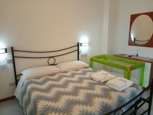 a bedroom with a bed and a mirror and a table at Appartamento La Libellula in Grosseto