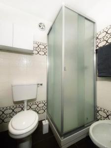 a bathroom with a toilet and a glass shower at Emma’s Tiny House in Pila