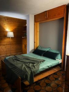 una camera con un letto e una parete in legno di Emma’s Tiny House a Pila