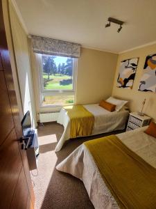 a hotel room with two beds and a window at Parador del Mar Marbella Maitencillo in Maitencillo