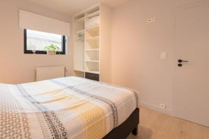 Schlafzimmer mit einem Bett und einem Fenster in der Unterkunft Villa Stijn in Middelkerke
