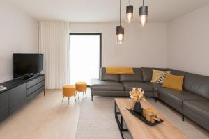 ein Wohnzimmer mit einem Sofa und einem Tisch in der Unterkunft Villa Stijn in Middelkerke