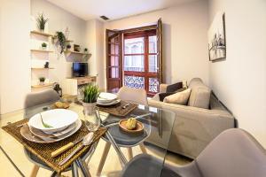 un soggiorno con tavolo e divano di CARTAGENAFLATS, Apartamentos Calle Mayor, CITY CENTER a Cartagena