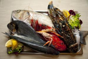 a tray of fish and vegetables on a table at Nascar Hotel in Santa Maria Navarrese